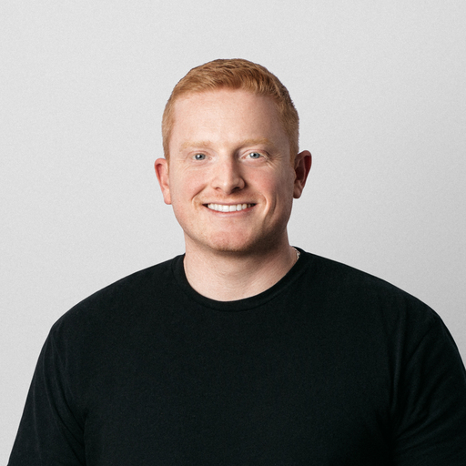 Portrait of a man with short blonde hair, smiling at the camera.