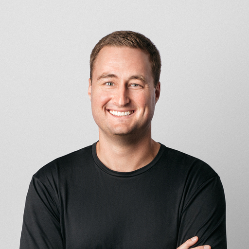 Portrait of a man with short blonde hair, smiling at the camera.