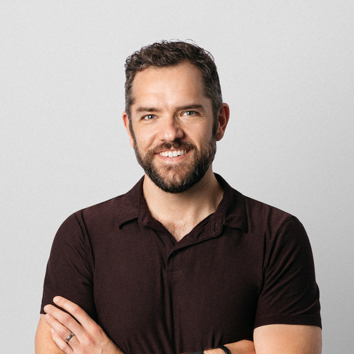 Portrait of a man with short brown hair, smiling at the camera.